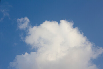 It's a blue sky with atmospheric puffy clouds.