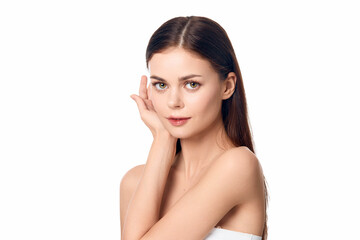 Beautiful young woman with hands on her face, closeup portrait on white background