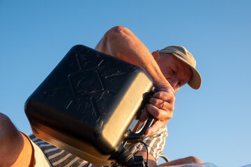 Stockholm, Sweden A man uses a jerry can to fill a boat gas tank with gasoline.