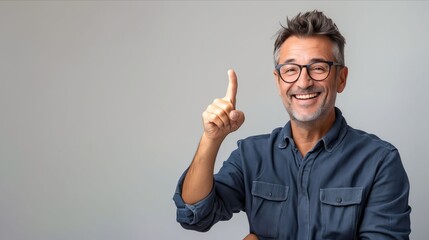 A man in glasses pointing up with his finger.