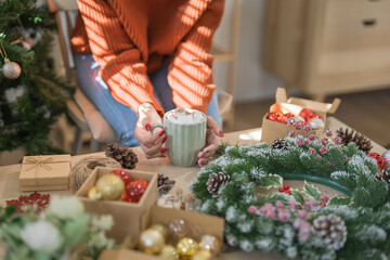 Woman holding cup of aromatic cocoa with marshmallows. Christmas eve with cup of tasty hot chocolate cozy holiday atmosphere at home