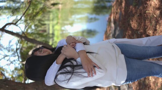 Mexican mother and her teenage daughter at the park, mothers day concept, vertical video