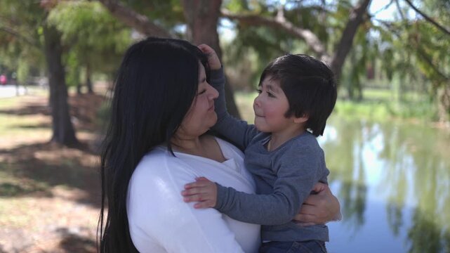 Mexican mother hugging her son at the park mothers day concept