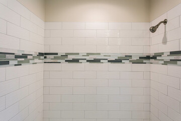 Modern Shower With White Tile Walls And A Decorative Horizontal Stripe