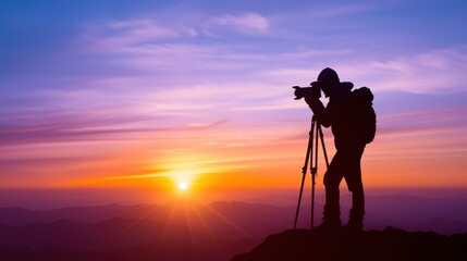 Silhouetted photographer with tripod captures stunning sunset on mountain peak, vibrant sky colors create a breathtaking moment.