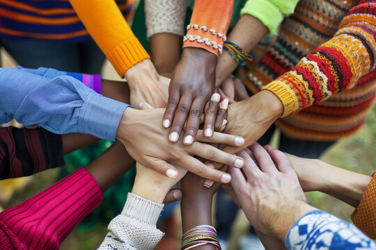 portrays a diverse group of volunteers joining hands in unity