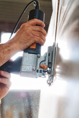 Carpenter using jigsaw cutting wood in workshop