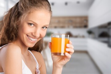 A young happy healthy woman drinks juice.