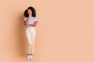 Full size photo of nice young woman look interested empty space wear t-shirt isolated on beige...