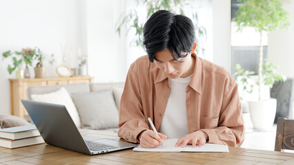 自宅で資格の勉強をする男性