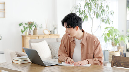 自宅で資格の勉強をする男性