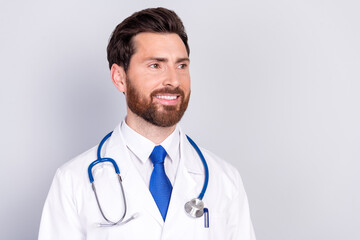 Photo of professional doctor man look empty space wear white coat isolated on grey color background