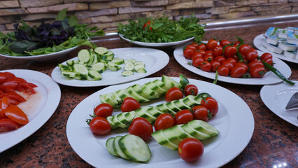Tomatoes, cucumbers, cheese, pastries and olives prepared at the open buffet for breakfast