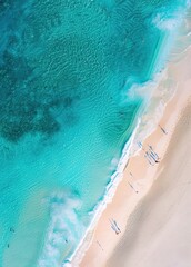 Fototapeta premium Aerial view of turquoise water and sandy beach with people in the distance.