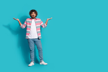 Photo of impressed shocked young man wear stylish striped clothes raise hands empty space isolated on cyan color background