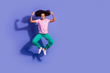 Full length photo of lovely young lady jump flexing muscles dressed stylish pink garment isolated on violet color background