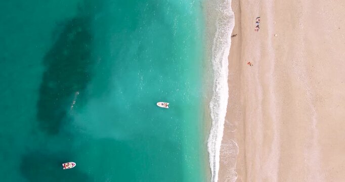 Inflatable Boats Off The Shore Of Cala Sisine Beach On Gulf of Orosei In Sardinia, Italy. aerial topdown, vertical shot