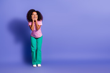 Naklejka premium Full body photo of attractive young woman amazed look empty space dressed stylish pink clothes isolated on violet color background