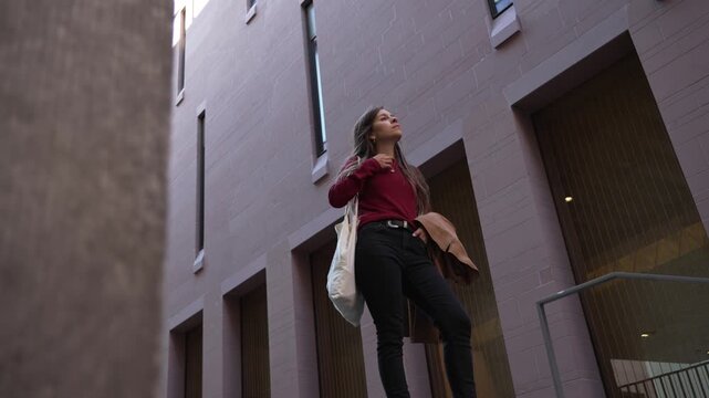 Brunette female model woman casual smart dressed in city, low level shot