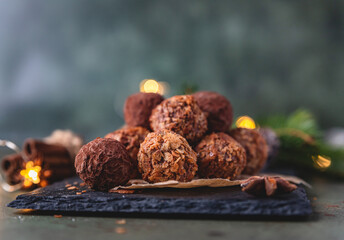 Homemade chocolate truffles, stone concrete table background with festive holiday decoration. Christmas Dessert