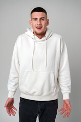 Fototapeta premium Young Man Looking Surprised Against a Gray Background