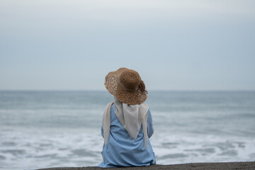 A woman sits alone and enjoys the view of the beach