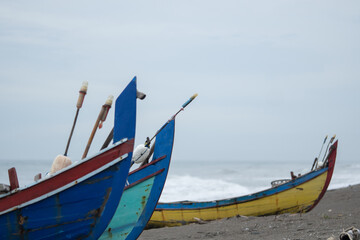 A view of a traditional Indonesian fishing boat being pulled up onto the beach