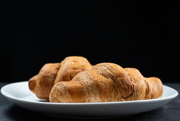 a plate of croissants on black background
