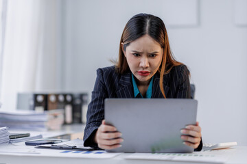 Portrait of tired  business asian woman sitting at a work. documents tax laptop computer in office. Sad, unhappy, Worried, Depression, or overworked, failure employee life stress concept	