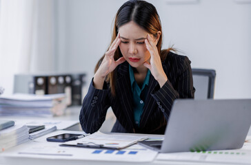 Portrait of tired  business asian woman sitting at a work. documents tax laptop computer in office. Sad, unhappy, Worried, Depression, or overworked, failure employee life stress concept	