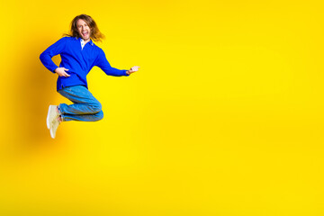 Photo of cheerful optimistic crazy man wear stylish blue clothes empty space isolated on yellow color background