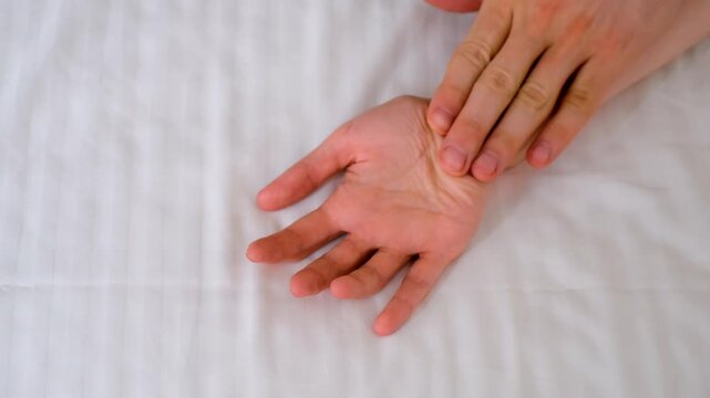 Man and woman holding hands lying in bed making love, hands close-up. Sex, intimate life, pleasure and love concept. Two lovers having a sex holding hands, sensual gesture.