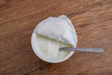 Fototapeta premium Plastikowy kubeczek z kwaśna śmietaną, widok z góry 