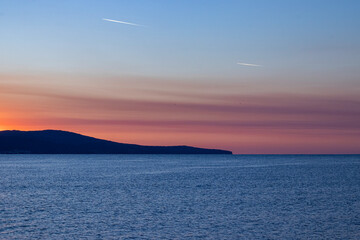 the sky over the sea before dawn, traces of airplanes in the sky