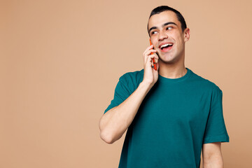 Young middle eastern man wears blue t-shirt casual clothes talk speak on mobile cell phone...
