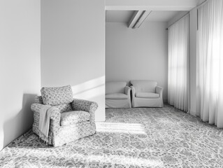 Bare and minimalistic living space with a sofa and chair facing each other.