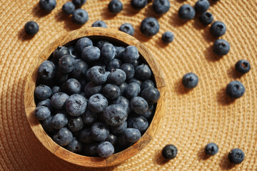 Fresh blueberries in a wooden bowl on a beige napkin