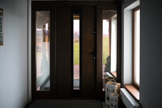 Main entrance/exit of a villa in a modern style. Front entrance to the house. Design of wooden doors with glass inserts in a hotel.