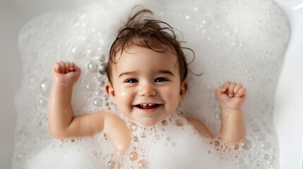Smiling baby in a bubble bath with arms raised and a joyful expression, surrounded by soapy bubbles.