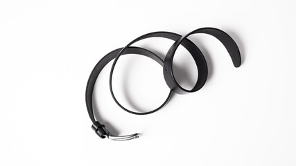 Black leather belt with matte metal buckle close-up isolated on white background. Fashionable unisex accessory for trousers, jeans, dress. Luxury male strap for man and woman. Haberdashery goods