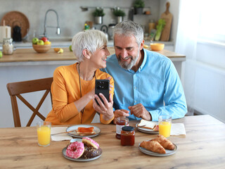 woman man senior couple home mobile phone phone retirement communication breakfast wife husband elderly together texting smartphone using modern message two internet online