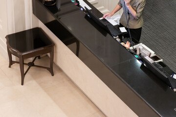 Asian receptionist working at counter