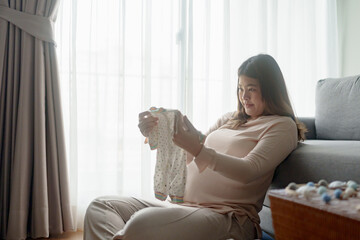 Pregnant woman preparing her baby clothes for maternity at hospital
