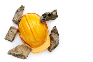 Yellow construction worker helmet with broken concrete blocks