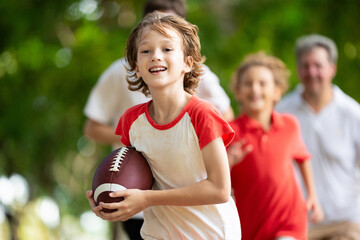 Family playing American football. Kids play rugby