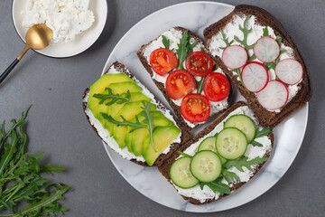 Healthy sandwiches with cottage cheese, cucumber, arugula, avocado, tomato