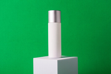 White sunscreen bottle on green background. Sunscreen concept. Skin care concept. Copy space.