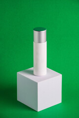 White sunscreen bottle on green background. Sunscreen concept. Skin care concept. Copy space.