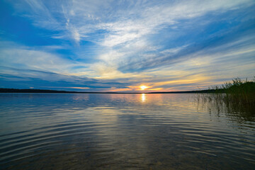 Obraz premium Sunset panorama over the lake with picturesque clouds.
