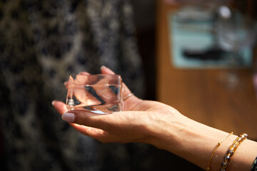 hand holds ice for a cocktail and cuts it
